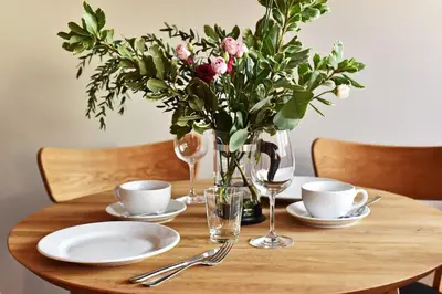 a wooden table with a vase of flowers on it at Domillion New modern Vilnius old town studio U2303 in Vilnius