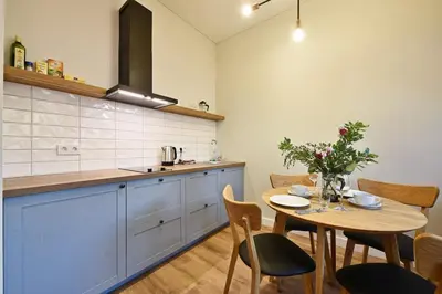 a kitchen with a wooden table and a dining room at Domillion New modern Vilnius old town studio U2303 in Vilnius