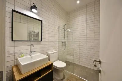 a bathroom with a sink and a toilet and a mirror at Domillion New modern Vilnius old town studio U2303 in Vilnius