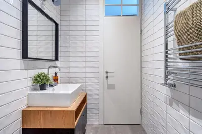a white bathroom with a sink and a mirror at Domillion New modern Vilnius old town studio U2304 in Vilnius
