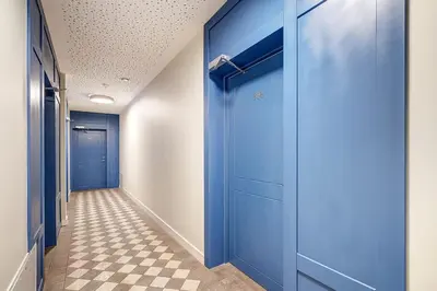 a hallway with blue doors and a checkered floor at Domillion New modern Vilnius old town studio U2304 in Vilnius