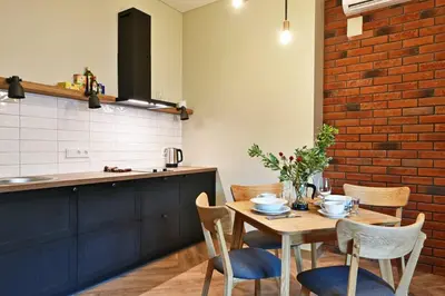 a kitchen with a wooden table with chairs and a counter at Domillion 1bdr New old town apt U2305 in Vilnius