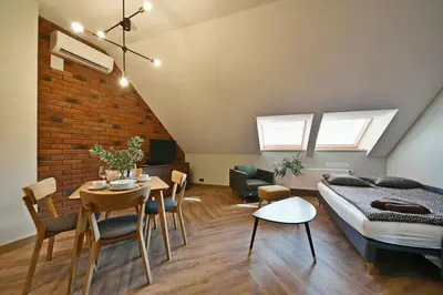 a bedroom with a bed and a table and chairs at Domillion 1bdr New old town apt U2305 in Vilnius