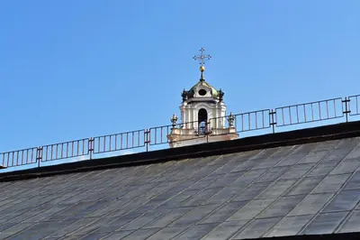 a clock tower on top of a building with a roof at Domillion 1bdr New old town apt U2305 in Vilnius