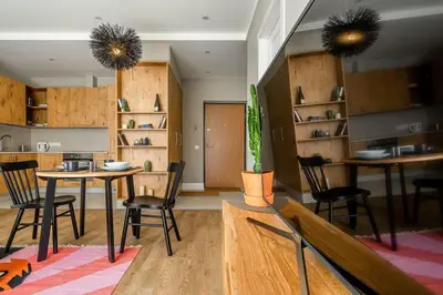 a living room with a table and chairs and shelves at Domillion 2bdr New Scandinavian old town apt N2A5 in Vilnius