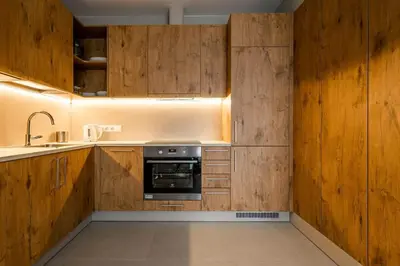 a kitchen with wooden cabinets and a sink and a stove at Domillion 2bdr New Scandinavian old town apt N2A5 in Vilnius