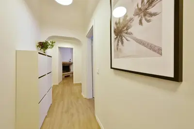 a hallway with white walls and a picture on a wall at Domillion Duplex Apt 11 ppl 4baths Vokieciu V10C in Vilnius