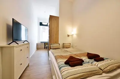 a bedroom with a large bed with a flat screen tv at Domillion Duplex Apt 11 ppl 4baths Vokieciu V10C in Vilnius