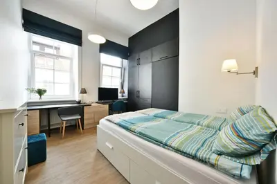 a bedroom with a bed and a desk in it at Domillion Duplex Apt 11 ppl 4baths Vokieciu V10C in Vilnius