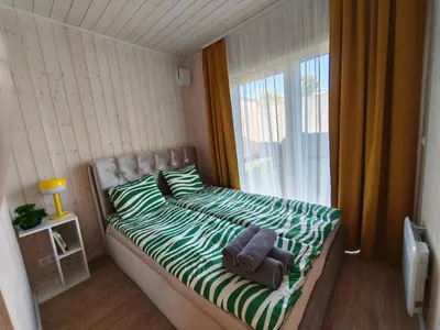 a bedroom with a bed with two towels and a window at Gervių takas 2