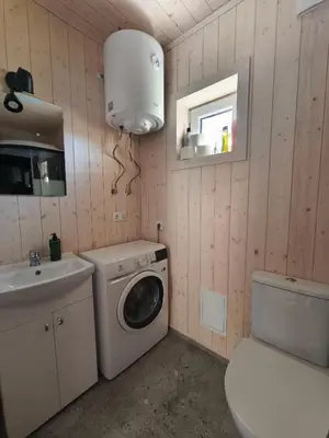 a bathroom with a washing machine and a sink at Gervių takas 2