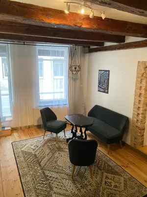 a living room with a couch and a table and chairs at Paupio krantas in Vilnius