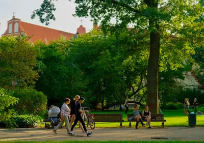a group of people walking in a park at Paupio krantas in Vilnius