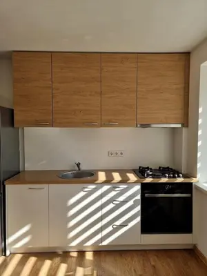 a kitchen with wooden cabinets and a sink at Vytautas central apartament in Kaunas