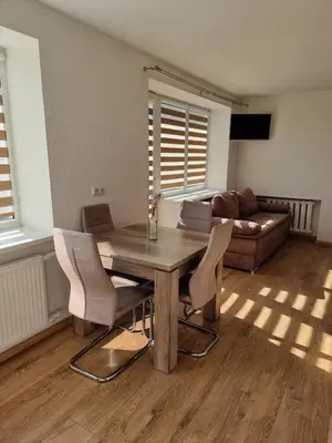 a living room with a wooden table and chairs at Vytautas central apartament in Kaunas