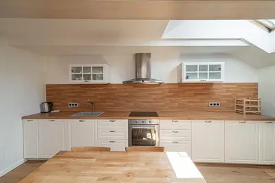 a kitchen with white cabinets and a stove top oven at Spacious 3 BDR apartment in Old Town in Vilnius