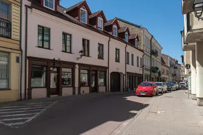 a red car parked on a street next to buildings at Spacious 3 BDR apartment in Old Town in Vilnius