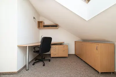 an attic office with a desk and a chair at Spacious 3 BDR apartment in Old Town in Vilnius