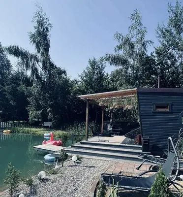 a house with a deck next to a body of water at Forest Resort House
