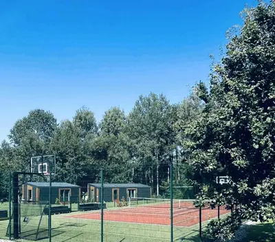 a tennis court with a net on a court at Forest Resort House