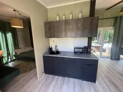 a kitchen with a black island in a room at Forest Resort House