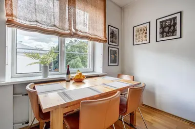 a dining room with a wooden table and a window at Elegant 2-Bedroom in city center in Vilnius