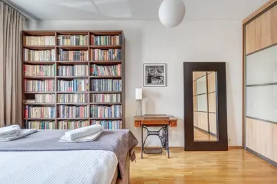 a bedroom with a bed and a book shelf filled with books at Elegant 2-Bedroom in city center in Vilnius