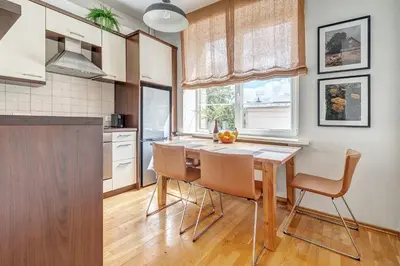 a kitchen with a wooden table and chairs at Elegant 2-Bedroom in city center in Vilnius