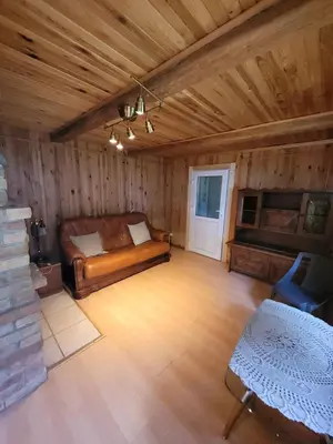 a bedroom with a bed in a room with wooden walls at Šeimos namelis nr2-Mindūnų sodyba in Pakopi