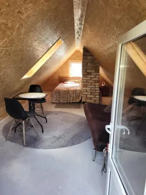 a bedroom with a bed and a table and chairs at Šeimos namelis nr2-Mindūnų sodyba in Pakopi