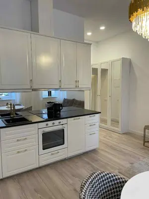 a kitchen with white cabinets and black counter tops at Luxury Apartment Self Check-In in Vilnius
