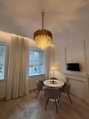 a dining room with a chandelier and a table and chairs at Luxury Apartment Self Check-In in Vilnius
