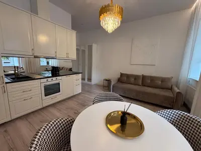 a kitchen and living room with a table and chairs at Luxury Apartment Self Check-In in Vilnius