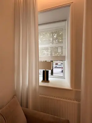 a window with a white curtain and a lamp at Luxury Apartment Self Check-In in Vilnius