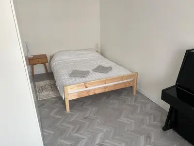 a small bed in a room with a television at Next door airport apartmens in Karmėlava