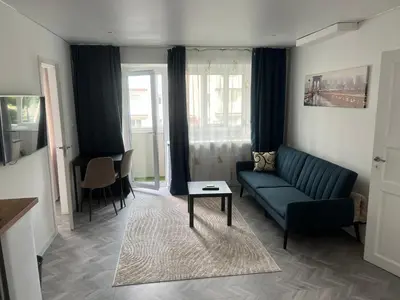 a living room with a couch and a table at Next door airport apartmens in Karmėlava