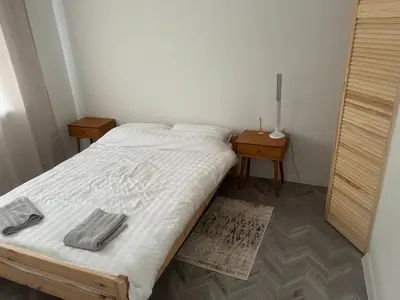 a small bedroom with a bed and two night stands at Next door airport apartmens in Karmėlava