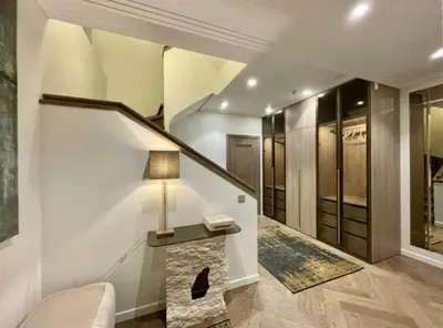 a living room with a staircase and a lamp on a table at sf ghjk in Užliedžiai