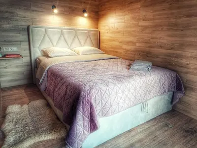 a bedroom with a bed in a wooden wall at Tytų Vila in Tytuvėnai