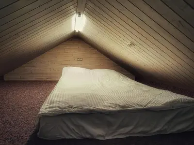 a bed in a room with a wooden wall at Tytų Vila in Tytuvėnai