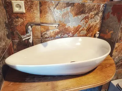 a white sink on a wooden counter in a bathroom at Tytų Vila in Tytuvėnai