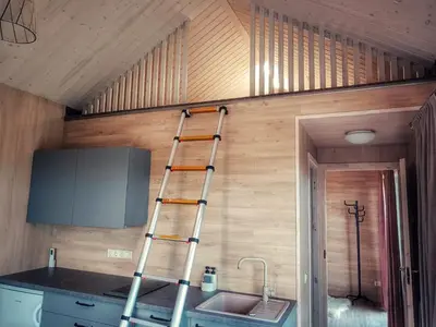 a ladder is on the wall of a kitchen at Tytų Vila in Tytuvėnai