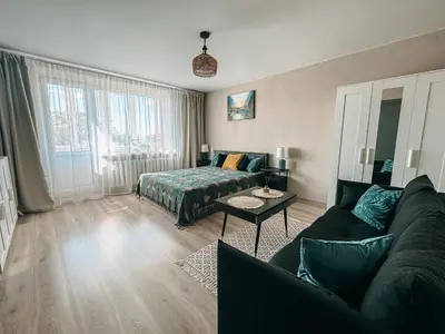 a living room with a couch and a bed at Central Park Apartment in Šiauliai