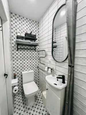 a bathroom with a toilet and a sink and a mirror at Central Park Apartment in Šiauliai