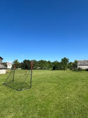 an open field with a net in the grass at Bocmano vila in Meteliai