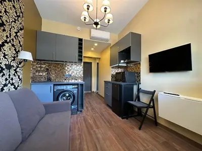 a living room with a couch and a washer and dryer at Jovarelis in Vilnius