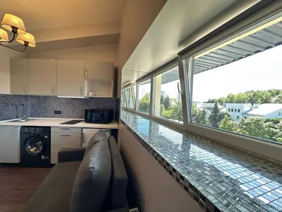 a kitchen with a couch and a large window at Jovarelis in Vilnius