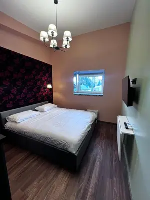 a bedroom with a large bed and a window at Jovarelis in Vilnius