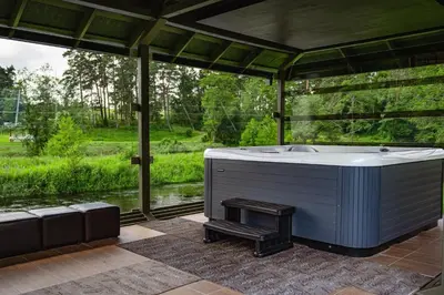 a bath tub in a room with a view at Romuvos Parkas in Zalioji