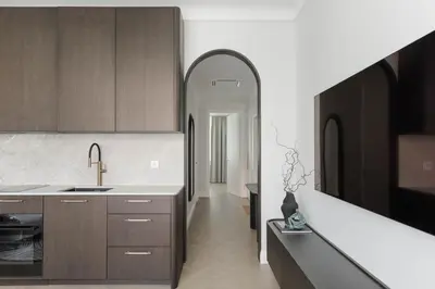 a kitchen with brown cabinets and a white counter top at SongInn Deco Apartment in Kaunas